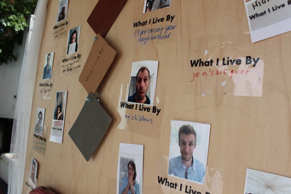   WhatILiveBy logos hang next to photos of individuals who have participated in the art installation. Photo Credit: Elizabeth Arakelian