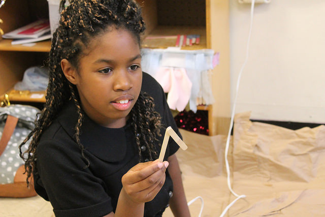 Brittney Rodriguez, 11, is making stick figures out of popsicle sticks to add to her 3D demonstration of what her birthday party will look like. Photo by Karis Rogerson