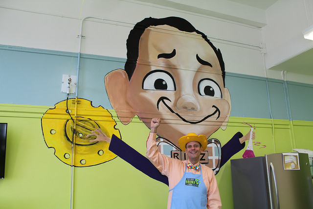 Green Bronx Machine Executive Director Stephen Ritz wears his famous cheese hat and bowtie in front of a painting of himself at Public School 55. If students are lucky, they may be rewarded for good behavior by getting to wear the hat and be "the big cheese." By Elizabeth Arakelian 