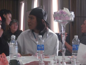 Aubrey Smith, dressed in a backwards cap and a button up T-shirt, sits back at a Navajo wedding. photo by Lauren Gerber 