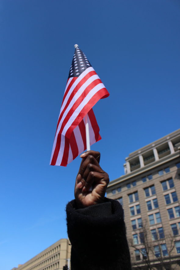 A protester waves an American flag as she marches at the March for Our Lives in Washington, D.C.