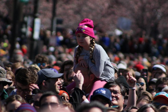 A girl sits on her father's shoulders in the crowd at March for Our Lives, Washington, D.C.