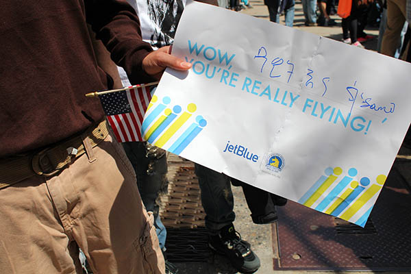  Aynalem holds a sign he prepared for the marathon’s finish line.