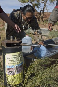 Earl Tulley fills containers with uranium-contaminated drinking water at Box Spring well in Black Falls, Ariz. Photo by Rachel Wise